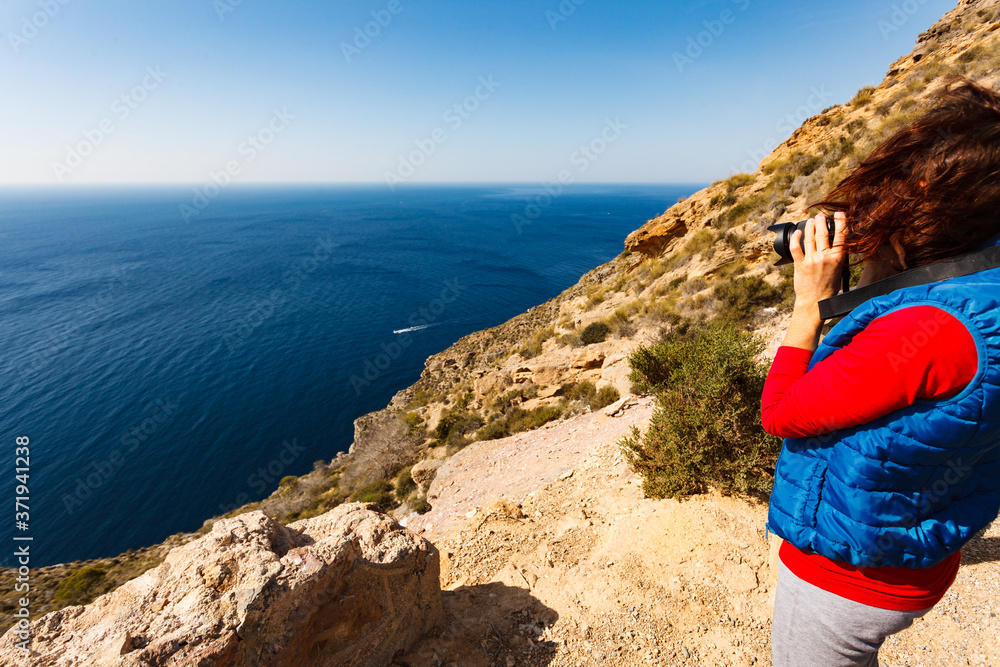 Woman take travel photo on sea coast, Spain