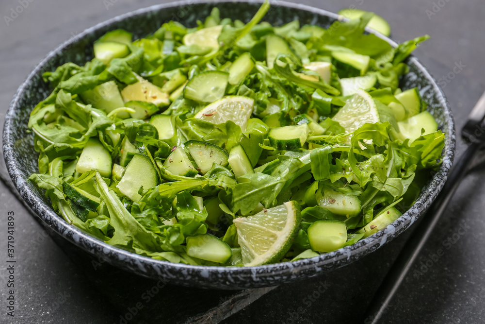 Plate with tasty cucumber salad on dark background Plate with tasty cucumber salad on dark background