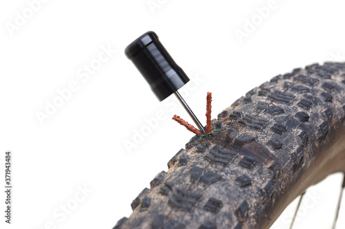 Foto Mountain bike tire puncture repaired using a glue strip isolated on white backgr