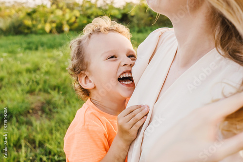 Little boy laugh in mothers hands. Smile close up. Outdoors, leisure activity.