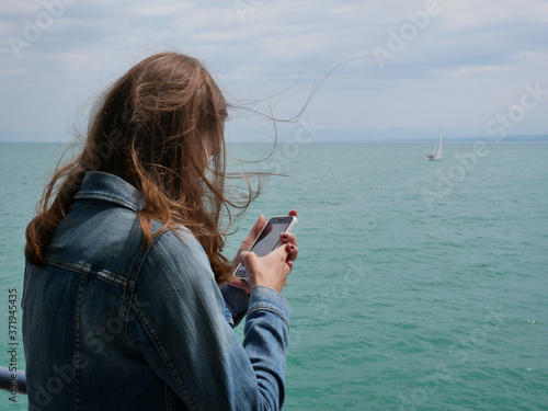 Jeune fille sur son téléphone en bateau 