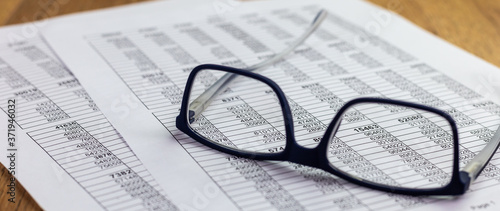 eyeglasses lying on a financial report with number tables on the office desk  business concept for finance 