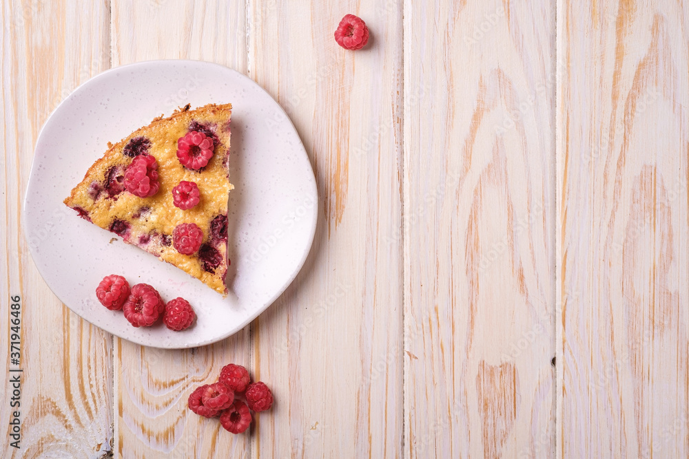 Sweet tasty pie slice with jellied and fresh raspberry fruits in plate, wooden table background, top view copy space