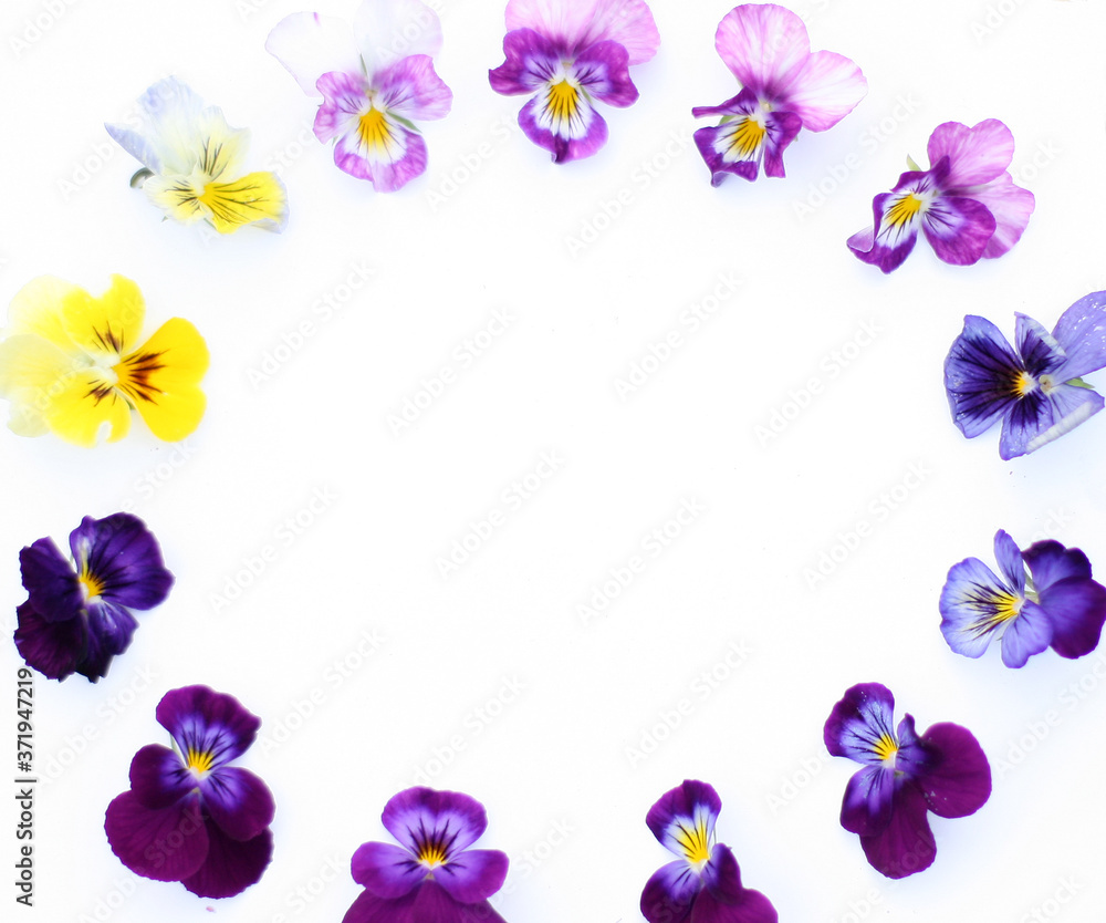 Round Frame with flowers and leaves. Top view background with pansy flowers. Flowers composition. Mock up with plants. Flat lay with flowers on white table. Woman day concept. Copyspace for text.