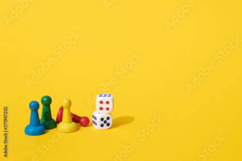 Chess pieces, game chips, Lotto barrels, draughts and playing cubes laid on a yellow background: entertainment, games at home for the whole family, the concept of table games. Board game. Board games