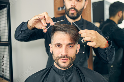 Handsome bearded male person looking at camera