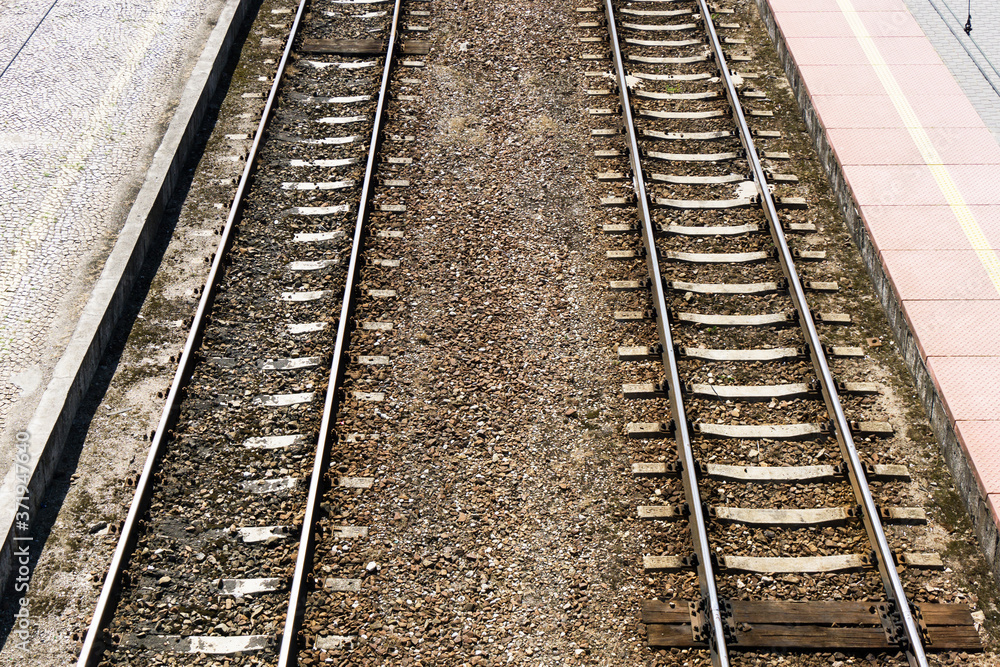 Railway top view background. Train transport industry. Rail track texture. Good and cheap way of transportation for cargo. Track ballast gravel made of crushed stone. Empty train station platform.