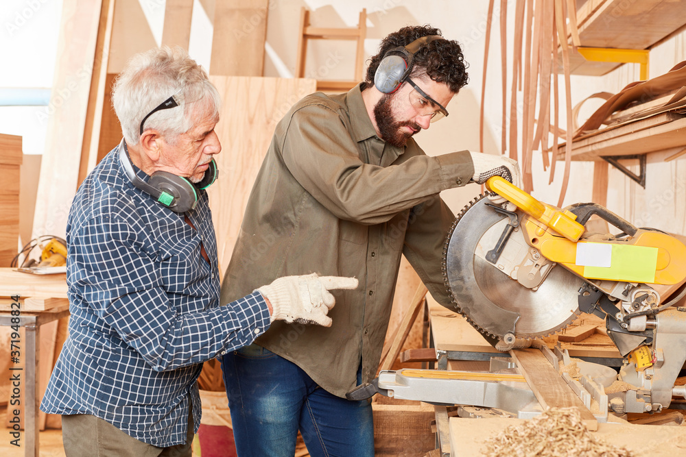 Alter Handwerker und Lehrling an der Kappsäge Alter Handwerker und Lehrling an der Kappsäge