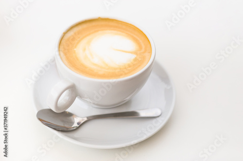 Coffee on a White Background. Coffee in a white cup with latte art. Flat lay, copy space.