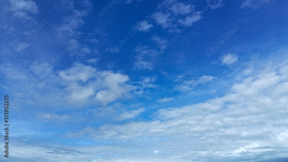 In a blue sky with light white translucent clouds, the wind is catching up to the horizon with clouds that completely cover the bright summer sky with a gray-white veil. In a blue sky with light white translucent clouds, the wind is catching up to the horizon with clouds that completely cover the bright summer sky with a gray-white veil.