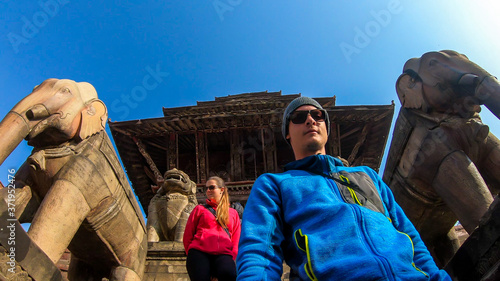 Couple walking down the stars of Nyatapola Temple in Bhaktapur Nepal. The Hindu temple has five stories. Discovering new cultures. A place of religious and historical worship. Lots of ornated statutes photo