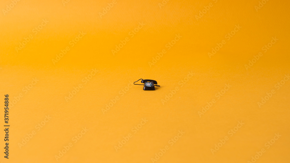 Fototapeta premium small phone on yellow background