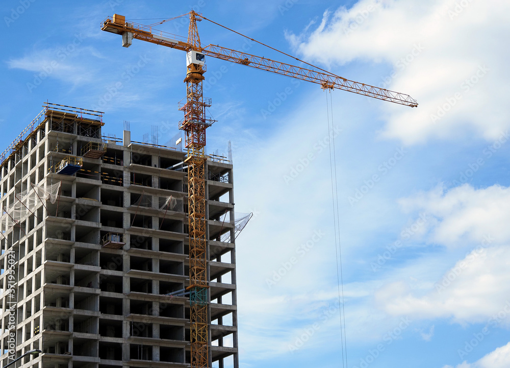 Construction of a modern frame residential building. Tower construction crane. Construction of a modern frame residential building. Tower construction crane.