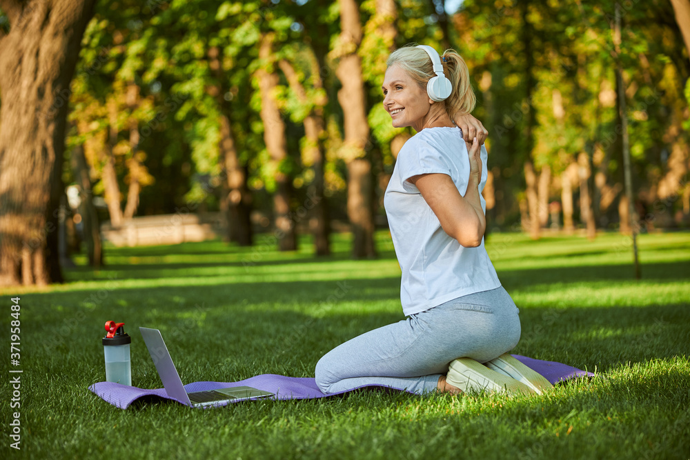 Cheerful woman doing morning gymnastics in park Cheerful woman doing morning gymnastics in park