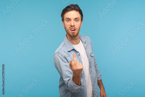 Bild auf Leinwand Portrait of aggressive vulgar man in worker denim shirt showing middle finger impolite gesture, demonstrating hate and disrespect, rebellious mood