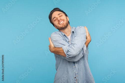 Fényképezés I love myself! Portrait of selfish narcissistic man in worker denim shirt embracing himself and smiling with expression of great ego, pleasure and self-esteem