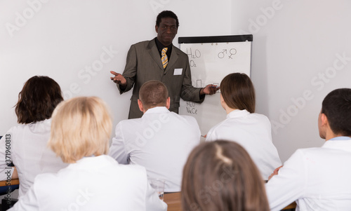 Smiling African American male professor giving presentation for medics in lecture hall