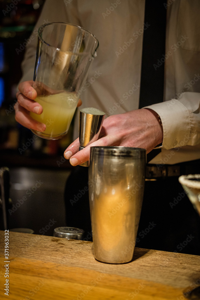 Night Club. Cocktails preparation. Margaritas in martini-glasses. Bartender hands making cocktails with a shaker. Elegant and classic.