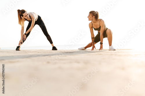 Women friends outdoors making stretching exercises