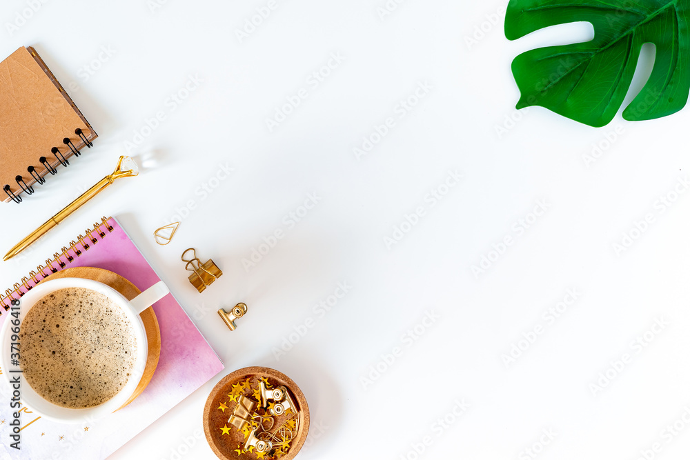Flat lay of white working table place background with cup of coffee putting on it. Top view glasses, leaf, golden paper binder clips, Notebook and pen. Desktop mock up scene with copy space Flat lay of white working table place background with cup of coffee putting on it. Top view glasses, leaf, golden paper binder clips, Notebook and pen. Desktop mock up scene with copy space