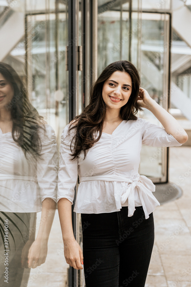 Smiling attractive woman wearing white blouse and black pants indoor Smiling attractive woman wearing white blouse and black pants indoor