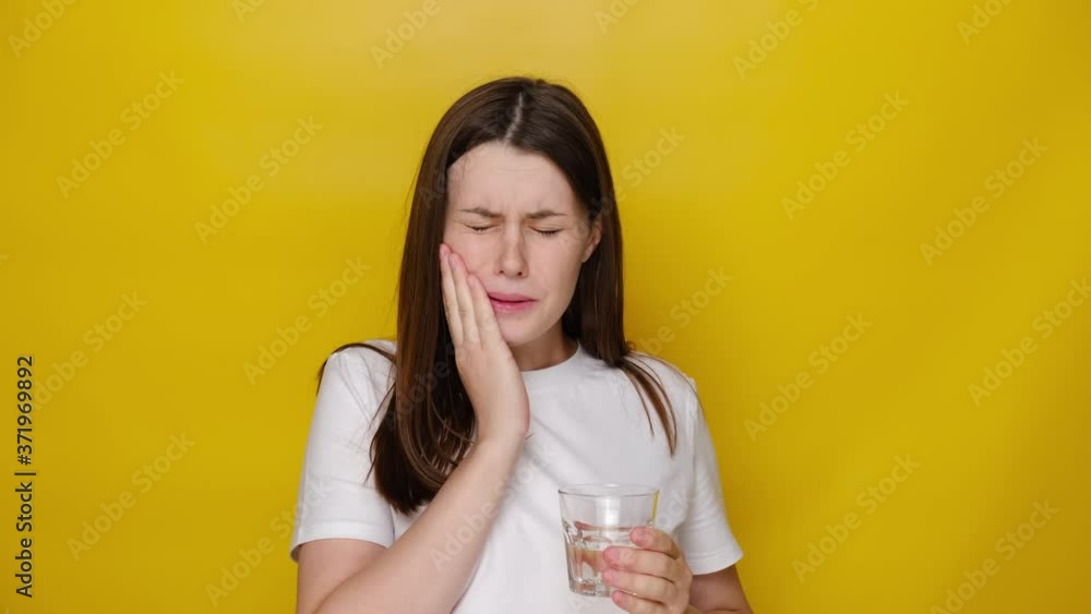 woman drinking ice water and feeling sudden terrible toothache