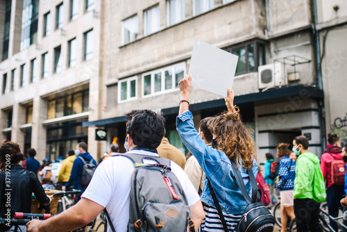 Young protesting people with signs on the city streets. Manifestation of activists.