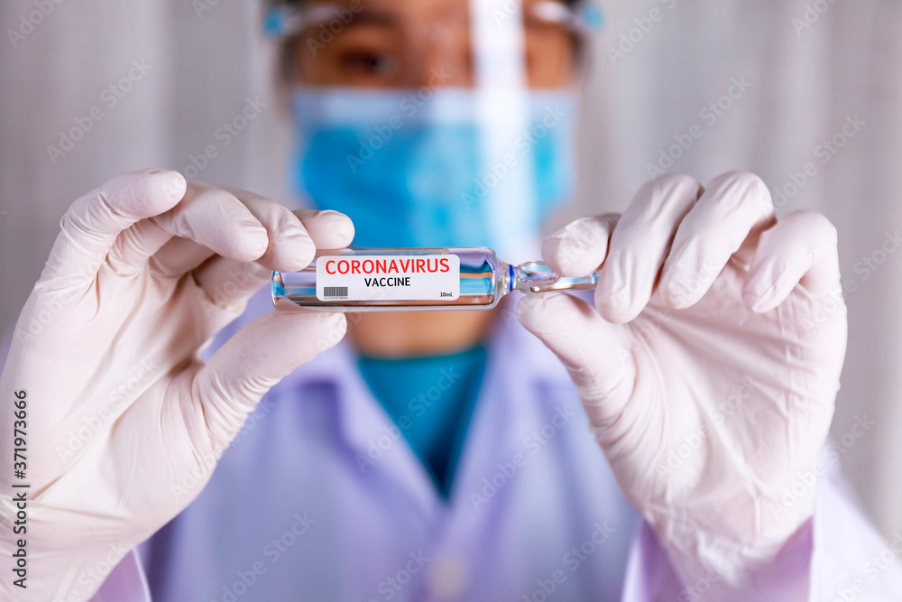 Covid-19 coronavirus vaccine. Close up hands of scientist show Covid-19 vaccine in glass vial. Hands of doctor wear latex glove holding Covid-19 vaccine in glass vial. Healthcare and medical concept. Covid-19 coronavirus vaccine. Close up hands of scientist show Covid-19 vaccine in glass vial. Hands of doctor wear latex glove holding Covid-19 vaccine in glass vial. Healthcare and medical concept.