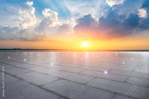 Empty square floor and lake with beautiful clouds at sunset.