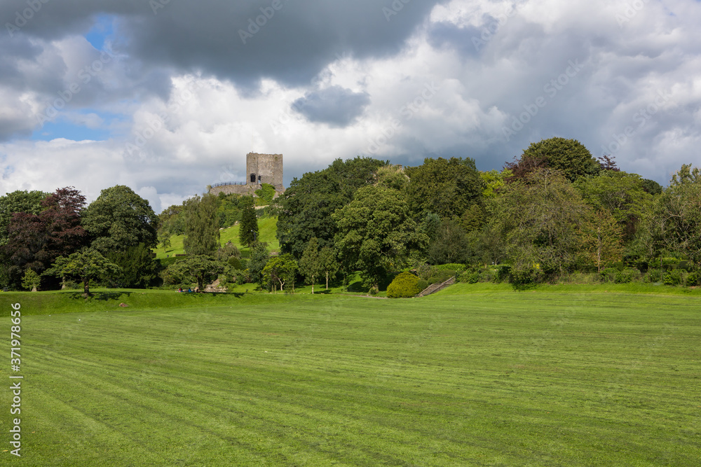 View of Clitheroe castle and trees with a blue sky background. Ribble valley public park