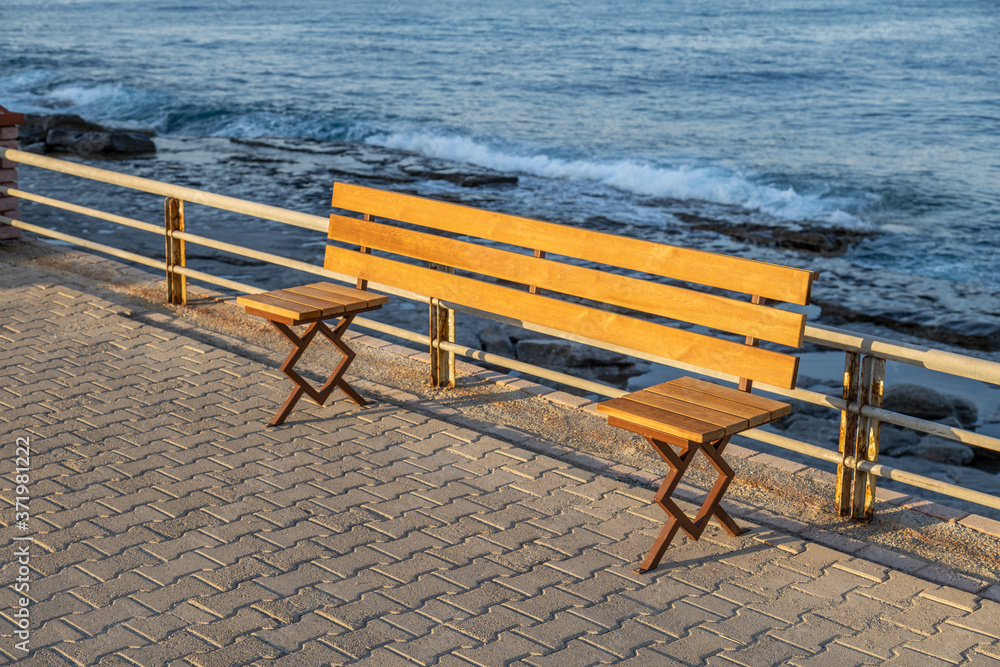 Social distancing bench on the shore. Post coronavirus era reality of recreation.