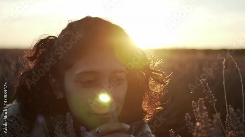Woman smelling and caressing flowers in a lavender field