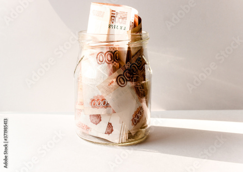 Russian banknotes with inscription "five thousand rubles" of 5000 rubles. Background made of money. Close up. Business, finance concept. Isolated. Five thousandth notes are packed in a glass jar