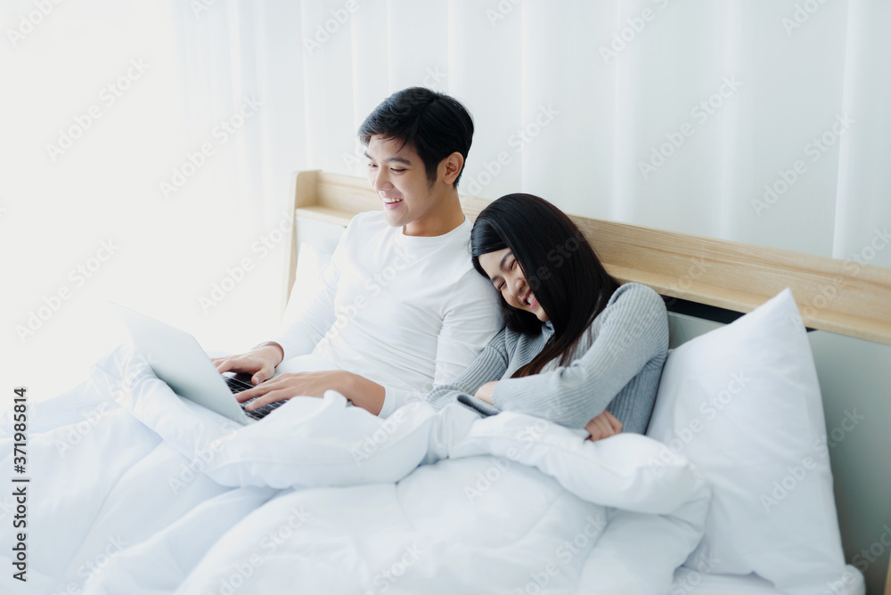 Fototapeta premium Asian couples rest and relax in bed.