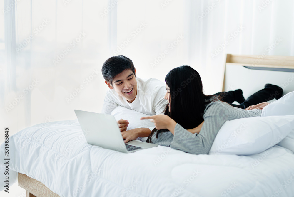 Smiling man looks happy. Watching movies via notebook Modern Technology in bed. Smiling man looks happy. Watching movies via notebook Modern Technology in bed.