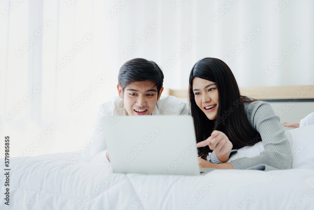 Lovers lie on their beds watching movies through notebook Modern Technology in their beds. Lovers lie on their beds watching movies through notebook Modern Technology in their beds.