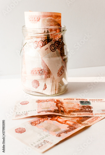 Russian banknotes with inscription "five thousand rubles" of 5000 rubles. Background made of money. Close up. Business, finance concept. Isolated. Five thousandth notes are packed in a glass jar