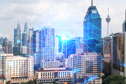 Abstract technology icons hologram over panorama city view of Kuala Lumpur, Malaysia, Asia. The concept of people networking and connections. Double exposure.