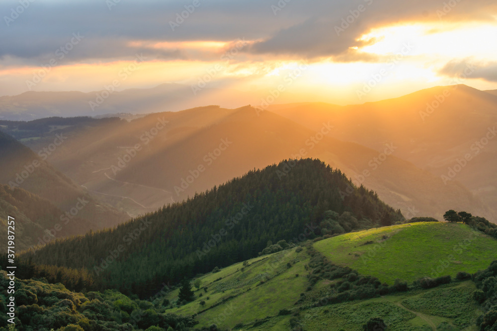 Fototapeta premium Sunset from Mount Ubieta, with the sun through the clouds