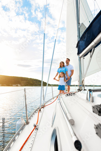 Family Sailing Relaxing During Yacht Ride Standing On Deck, Vertical © Prostock-studio