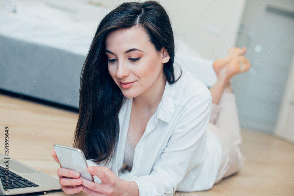Relaxed attractive lady with two modern gadgets at home Relaxed attractive lady with two modern gadgets at home