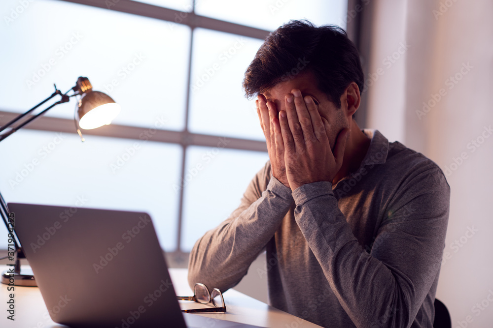 Tired Businessman Working Late Using Laptop At Desk In Office Rubbing Eyes Tired Businessman Working Late Using Laptop At Desk In Office Rubbing Eyes