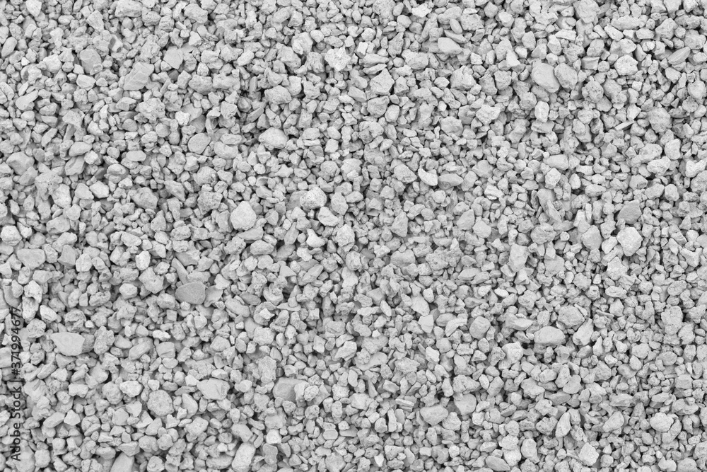 Gray small rocks ground texture. black small road stone background. gravel pebbles stone seamless texture. dark background of crushed granite gravel, close up. clumping clay