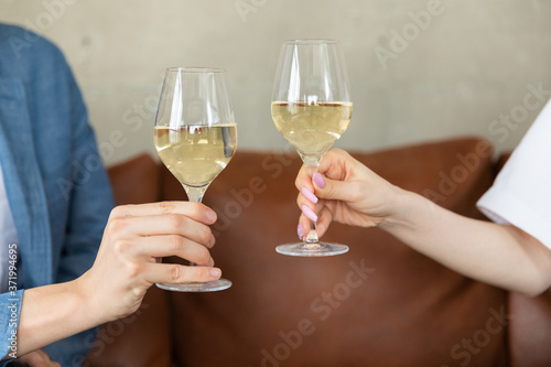 Couple sitting on sofa talking and drinking wine