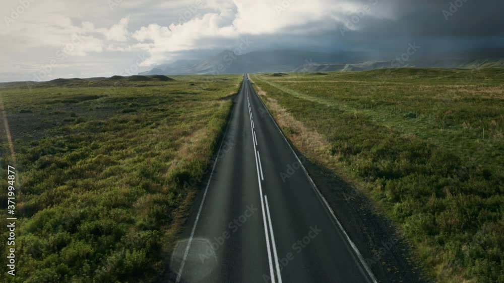 Aerial view of beautiful landscape with a highway in Iceland in summertime. Drone flying over asphalt road passes through the field.
Aerial view of beautiful landscape with a highway in Iceland in summertime. Drone flying over asphalt road passes through the field.