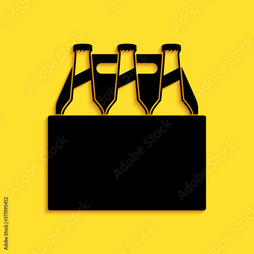 Black Pack of beer bottles icon isolated on yellow background. Case crate beer box sign. Long shadow style. Vector.