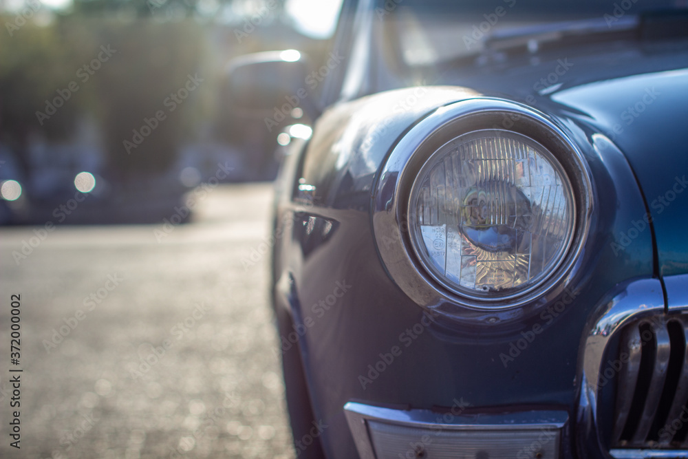 Close-up of a round headlight on an old car. On against the sun Close-up of a round headlight on an old car. On against the sun