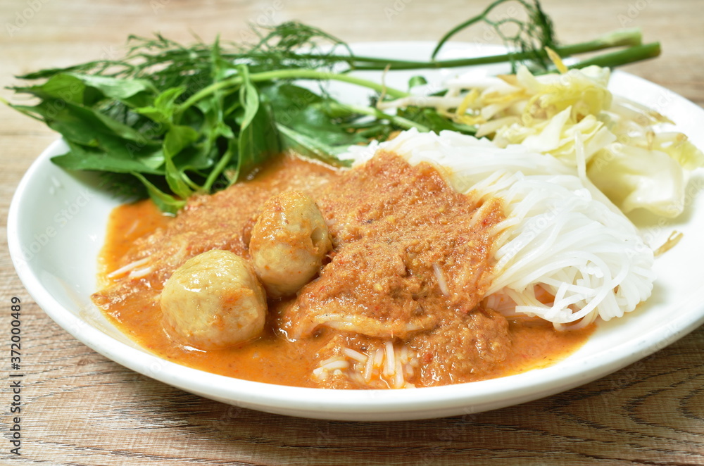 rice noodles dressing with meat ball fish coconut milk curry sauce and fresh vegetable on plate rice noodles dressing with meat ball fish coconut milk curry sauce and fresh vegetable on plate