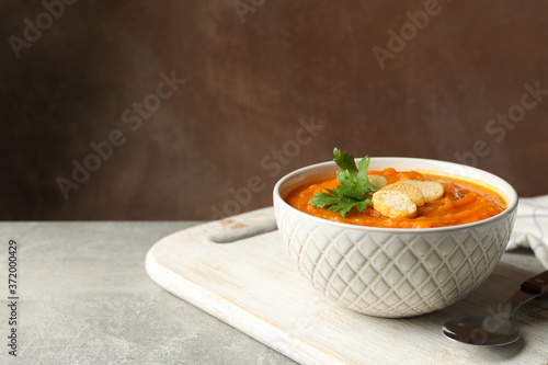 Composition with bowl of pumpkin puree with croutons on gray table