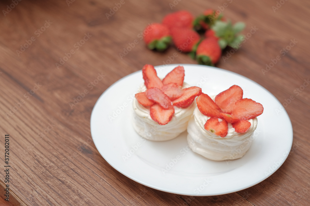Mini pavlovas with whipped cream and fresh strawberry Mini pavlovas with whipped cream and fresh strawberry